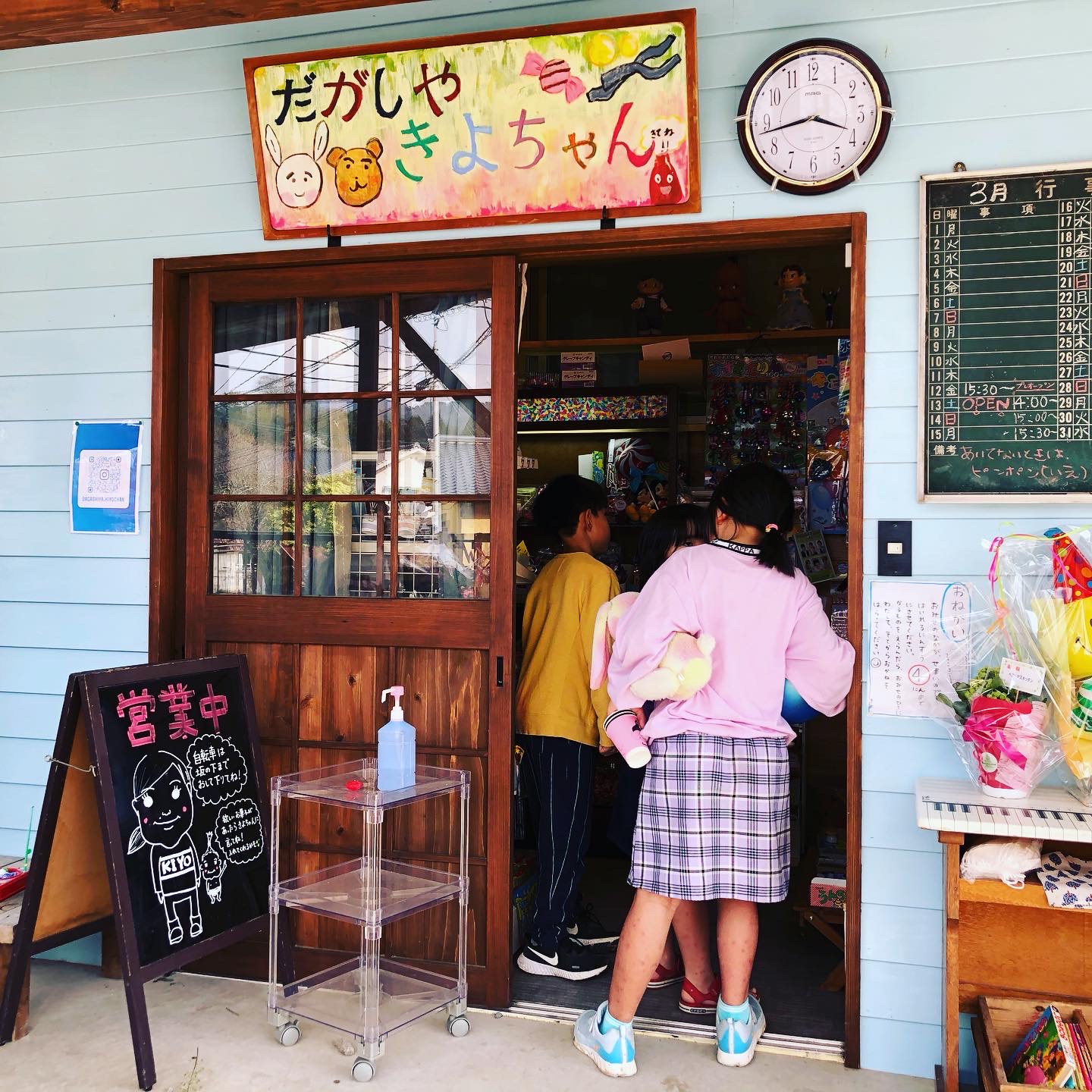 駄菓子屋きよちゃんの店舗入口で楽しそうに買い物する子どもたち