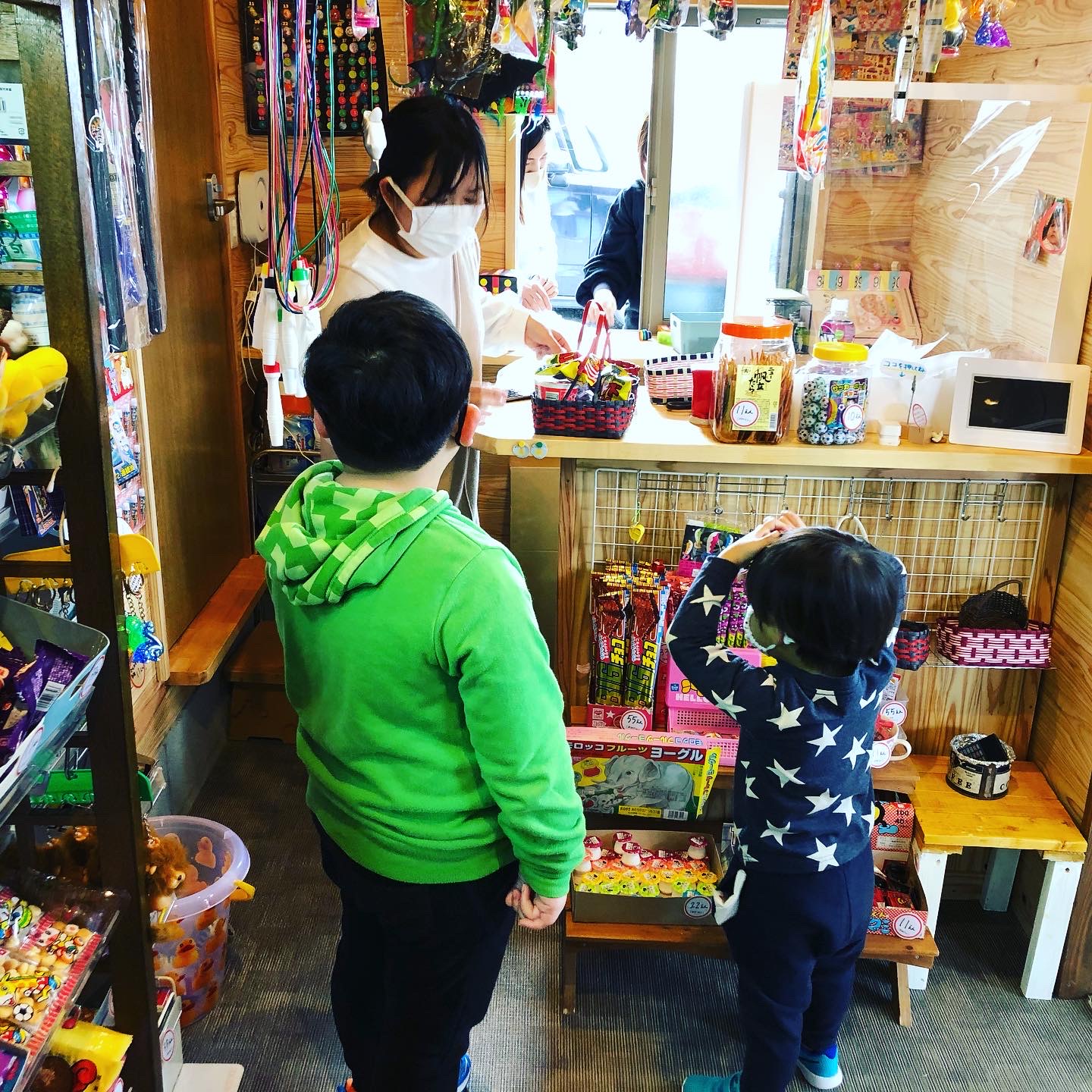 レジカウンターで駄菓子を選ぶ子どもたちの様子